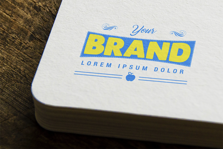 Some papers are on a table, and a colorful logo is on the paper